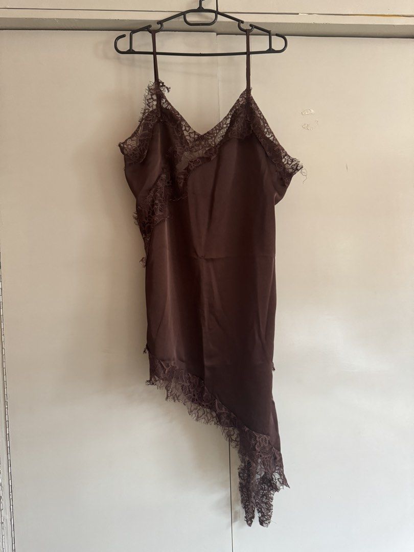 Brown asymmetrical lace cami top slip top (Category: Sleeveless) located in Taytay. Submitted by darkswan016 (Listing ID 1470829762, Image 1). Description: - Color: Dark brown - Material: Soft and silky satin fabric - Design: V-neck cut with delicate lace detailing on the front and back neckline - Straps: Thin spaghetti straps - Hemline: Asymmetrical hem with a chic, long draping side - Style: Perfect for layering or wearing on its own for a nigh