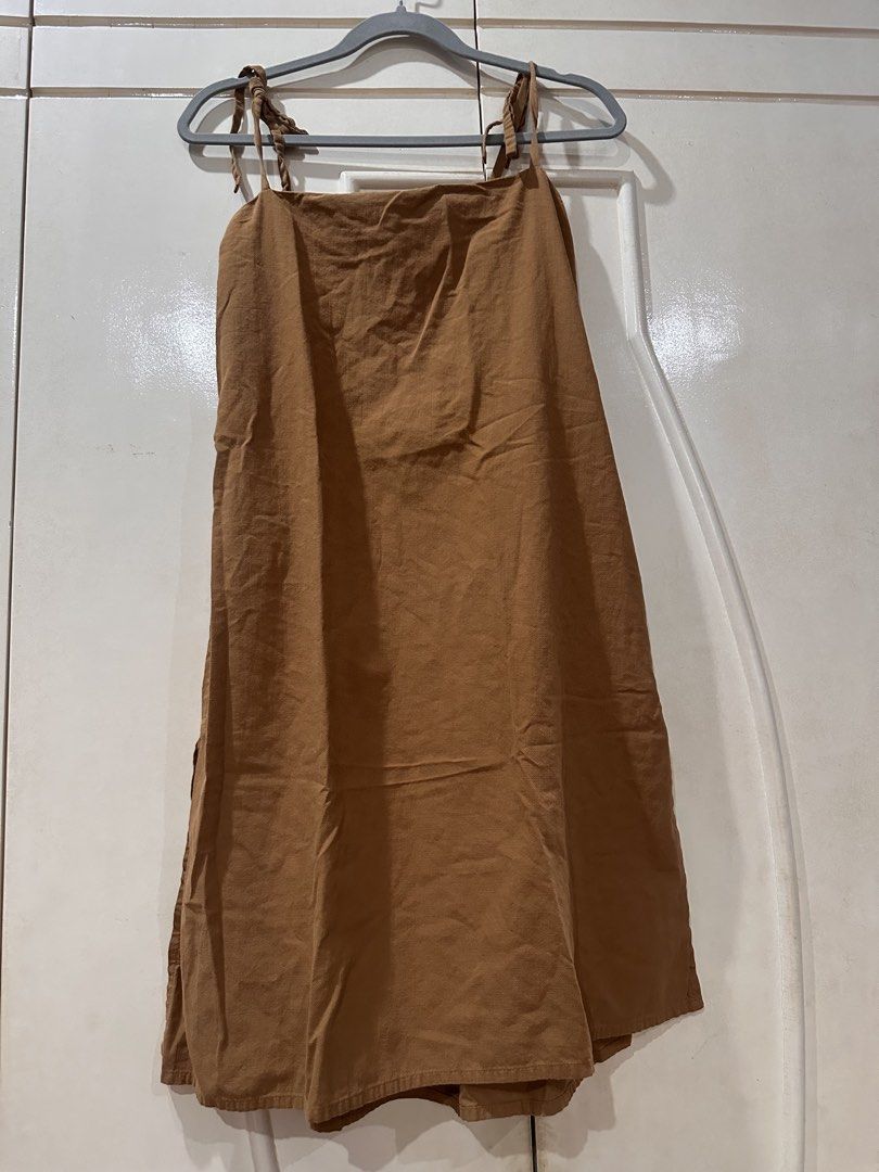 Brown Midi Dress with Tie Straps (Category: Dresses) located in Las Pinas. Submitted by novaglow (Listing ID 1470786214, Image 1). Description: - Color: Brown - Length: Midi (hits around mid-calf) - Details: Adjustable tie straps at shoulders, straight neckline, sleeveless - Material: Textured cotton-blend - Condition: Pre-loved, worn a few times, still in great shape - Style tip: Versatile basic that is easy to dress up or down.