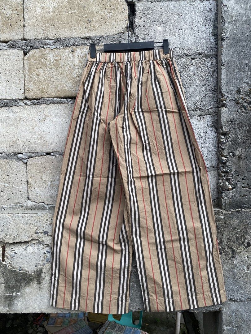 Burberry Striped Wide-Leg Pants (Category: Jeans) located in Candaba. Submitted by dejesus.bench17 (Listing ID 1470931727, Image 2). Description: - Brand: Burberry - Style: Wide-leg pants in classic beige with iconic striped pattern - Waistband: Elastic at the back for a comfortable fit - Closure: Front button with stylish anchor details - Pockets: Two functional front pockets - Condition: Clean, well-maintained, and gently used - Perfect for add
