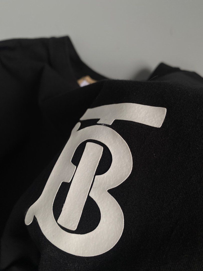 Burberry TB Monogram Logo Black T-Shirt (Category: Tshirts & Polo Shirts ) located in Cavite. Submitted by awuuu27 (Listing ID 1470748334, Image 3). Description: - Authentic Burberry t-shirt in timeless black - Size: XS (Made in Italy) - Material: Premium cotton - Design: White Thomas Burberry monogram print on chest, crew neck, short sleeves - Condition: Clean overall, inner tag still attached - Flaw note: Minor thread pull near the collar (refe