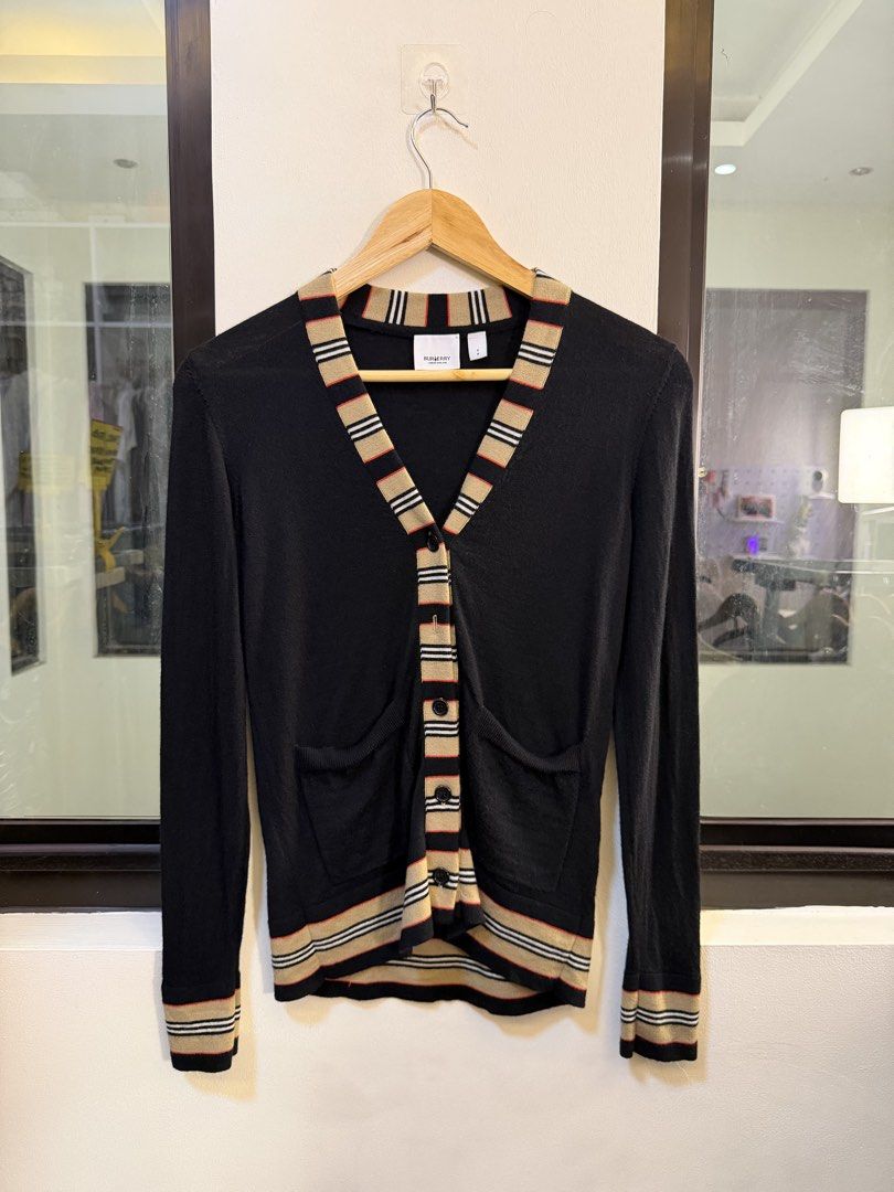 Burberry V-Neck Button-Up Cardigan Sweater (Category: Coats, Jackets and Outerwear) located in Paranaque City. Submitted by preluxeshop_ph (Listing ID 1470808707, Image 2). Description: Brand: Burberry London England -Style: V-Neck Button-Up Cardigan Sweater -Color: Black with Icon Stripe trim along the placket, collar, cuffs, and hem -Design Features: Front button closure, dual front patch pockets, V-neckline, and contrast signature striped ribb