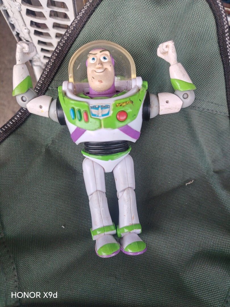 Buzz Lightyear Toy Story Action Figure (Category: Figurines & Statues) located in Manila. Submitted by mightypenguin_44c1b5 (Listing ID 1470797636, Image 1). Description: - Character: Buzz Lightyear from Toy Story - Design: Classic white, green, and purple suit with retracting helmet dome - Articulation: Movable arms and legs for dynamic posing - Condition: Sturdy plastic build with some scuffs and paint wear from previous play - Flaws: Missing t