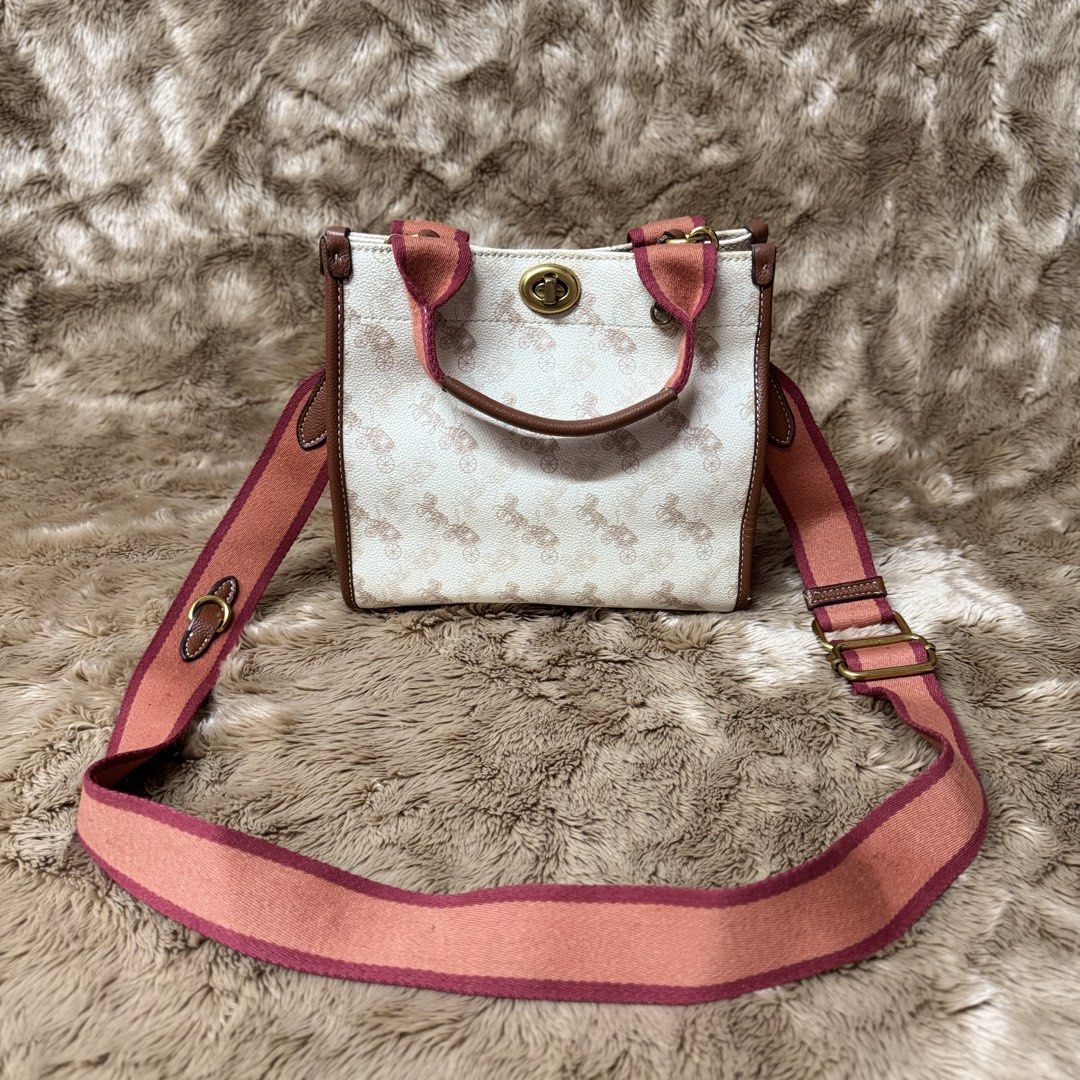 C*ACH FIELD TOTE (off) (Category: Luxury Bags & Wallets) located in Manila. Submitted by thebagbudget (Listing ID 1470786579, Image 1). Description: 🖤 C*ACH FIELD TOTE (off) ✨ Timeless style, everyday luxury! 🤎 👜 Printed coated canvas combined with polished pebble leather and refined leather trim 🖤 Chalk / White coated canvas with a soft pink/red-toned Horse and Carriage motifq ✨ Hardware: Brass / Antique gold-tone. 📏 Size: 8.5 (L) x 8.2 (H)