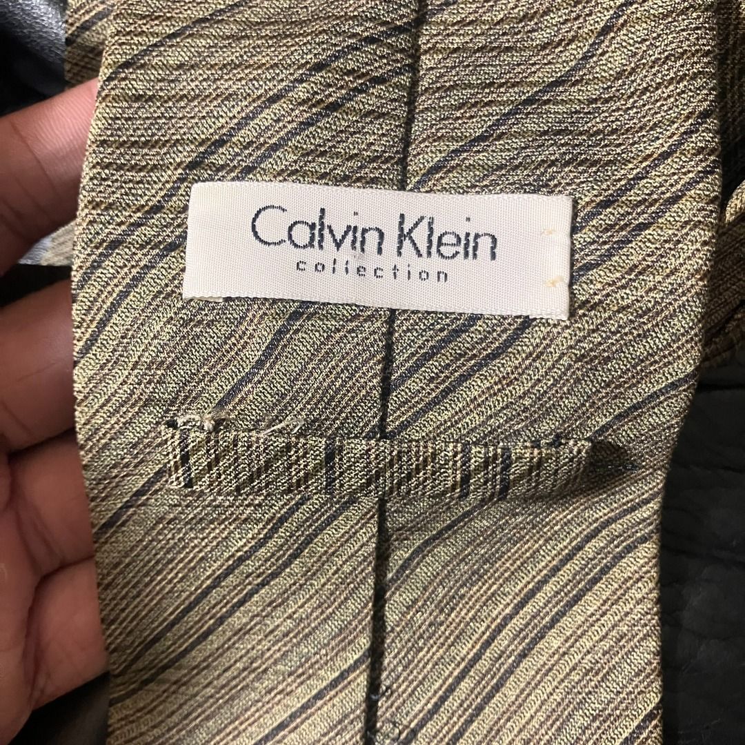 Calvin Klein Collection Striped Necktie (Category: Ties) located in Manila. Submitted by nellyfrustrado (Listing ID 1470809577, Image 2). Description: Item Specifics: Brand: Calvin Klein Collection (Features official brand tag and logo-lined tipping). Material: Textured woven fabric with a rich, tactile handfeel. Colorway: Earthy beige, tan, and dark brown striped pattern. Condition: 8.5/10 Excellent condition with minimal signs of gentle wear. D