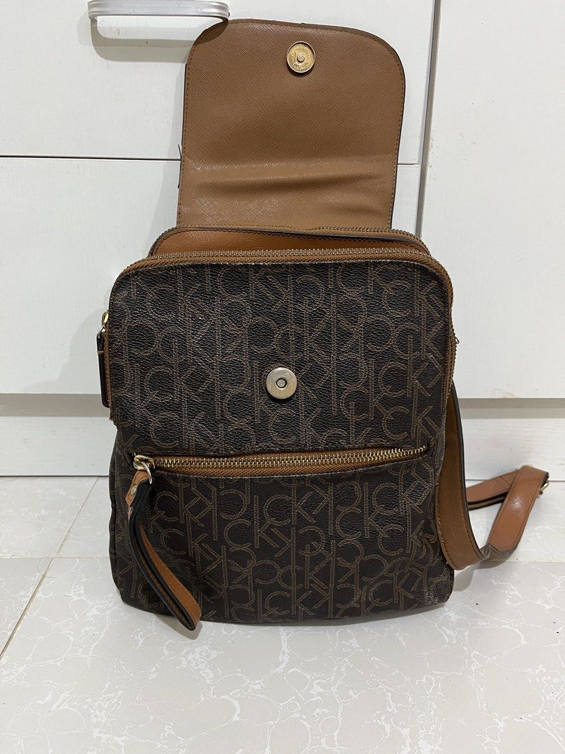 Calvin Klein Monogram Brown Tan Backpack (Category: Backpacks) located in Cainta. Submitted by rizeru_18 (Listing ID 1470751334, Image 3). Description: - Calvin Klein backpack in stylish brown monogram print - Dual security: flap top with magnetic snap closure plus a main zip compartment - Extra storage: convenient front zip pocket and exterior back zip pocket - Comfortable wear: adjustable shoulder straps and top grab handle - Organized interior