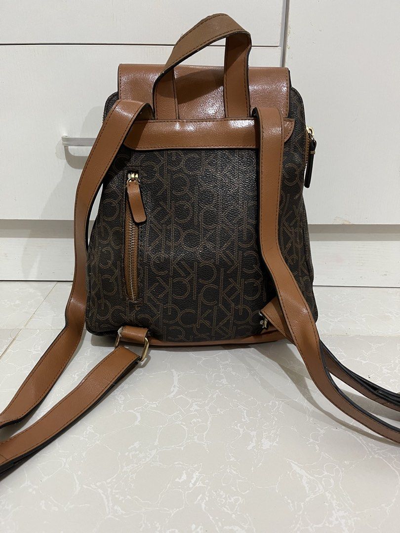 Calvin Klein Monogram Brown Tan Backpack (Category: Backpacks) located in Cainta. Submitted by rizeru_18 (Listing ID 1470751334, Image 2). Description: - Calvin Klein backpack in stylish brown monogram print - Dual security: flap top with magnetic snap closure plus a main zip compartment - Extra storage: convenient front zip pocket and exterior back zip pocket - Comfortable wear: adjustable shoulder straps and top grab handle - Organized interior