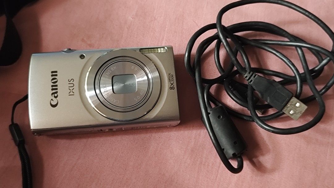 Canon IXUS 145 Digital Camera with USB Cable (Category: Cameras) located in Quezon City. Submitted by melizaak (Listing ID 1470921638, Image 1). Description: - Model: Canon IXUS 145 Digital Camera (Silver) - Condition: Powers on successfully with clear date and time setup menu - Lens: 8x optical zoom lens with 5.0-40mm focal range - Features: Built-in front flash and standard bottom tripod mount - Inclusions: Black USB cable with ferrite core fil