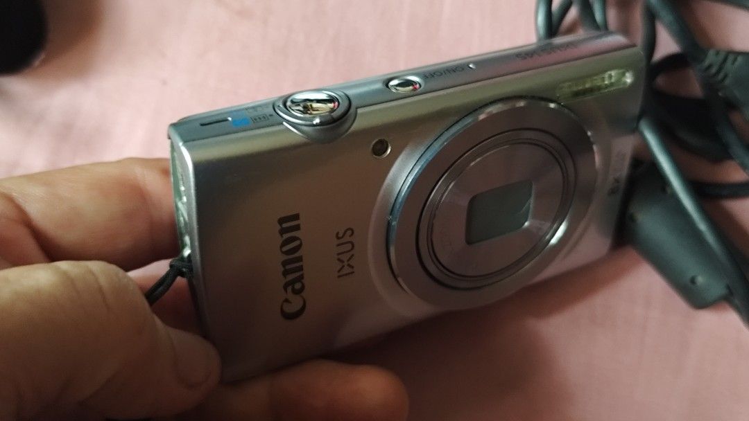 Canon IXUS 145 Digital Camera with USB Cable (Category: Cameras) located in Quezon City. Submitted by melizaak (Listing ID 1470921638, Image 2). Description: - Model: Canon IXUS 145 Digital Camera (Silver) - Condition: Powers on successfully with clear date and time setup menu - Lens: 8x optical zoom lens with 5.0-40mm focal range - Features: Built-in front flash and standard bottom tripod mount - Inclusions: Black USB cable with ferrite core fil