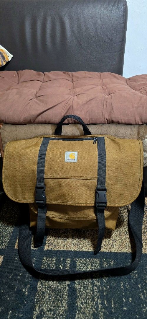 Carhartt Work In Progress Parcel Bag Brown Messenger Bag (Category: Sling Bags) located in Calamba. Submitted by elynkrenit24287 (Listing ID 1470808496, Image 3). Description: - Brand: Carhartt WIP May kaunting issue sa loob see pic nalang Excellent to as new - Color: Brown - Material: 100% durable and lightweight polyester - Closure: Large flap with dual buckle straps - Pockets: Front zip pocket for easy access - Carry Options: Top carry handle 