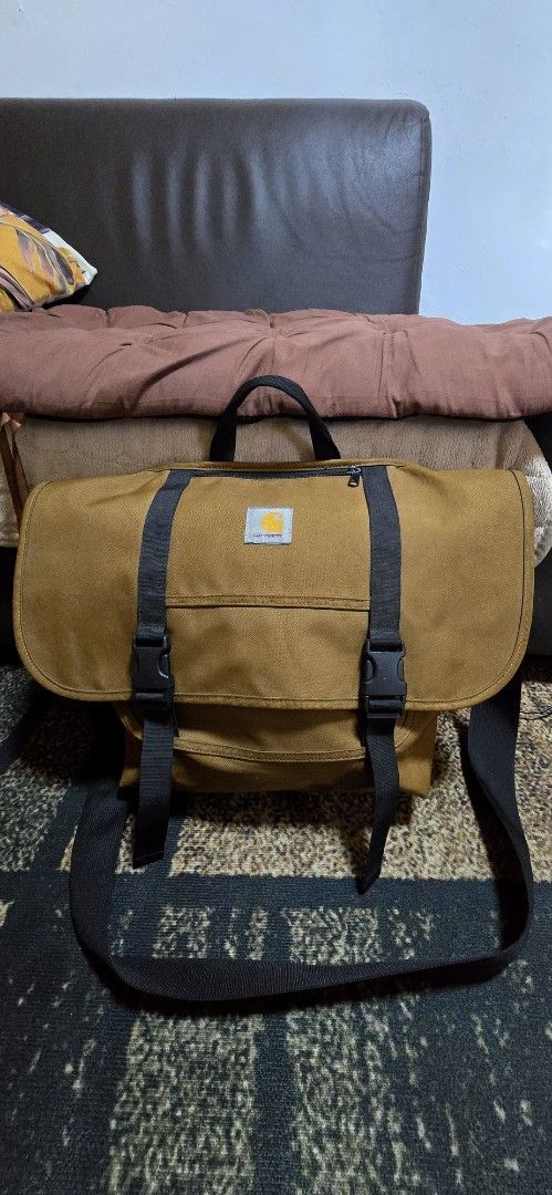 Carhartt Work In Progress Parcel Bag Brown Messenger Bag (Category: Sling Bags) located in Calamba. Submitted by elynkrenit24287 (Listing ID 1470808496, Image 2). Description: - Brand: Carhartt WIP May kaunting issue sa loob see pic nalang Excellent to as new - Color: Brown - Material: 100% durable and lightweight polyester - Closure: Large flap with dual buckle straps - Pockets: Front zip pocket for easy access - Carry Options: Top carry handle 