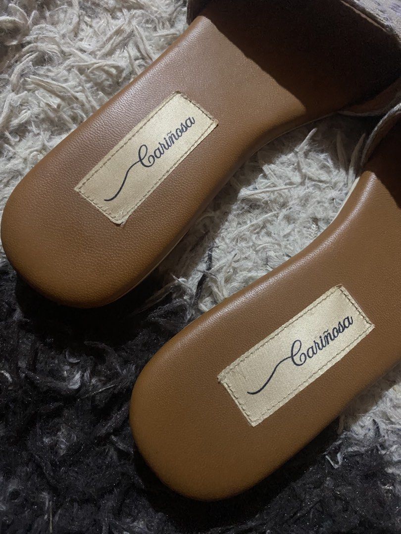 Cariñosa Purple Woven Pattern Slide Sandals Size 6 (Category: Flats & Sandals) located in Caloocan City. Submitted by remythrift (Listing ID 1470754989, Image 2). Description: - Brand: Cariñosa - Style: Slip-on sandals - Color: Tan and purple - Size: 6 (stamped on sole) - Upper: Textured woven pattern strap - Insole: Brown with stitched brand label - Sole: Low flat heel with textured rubber traction - Condition: Good, with slight wear at the toe 