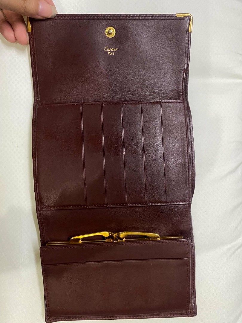 Cartier Bordeaux Leather Long Wallet (Category: Luxury Bags & Wallets) located in Naga. Submitted by mrwisethrifter (Listing ID 1470846799, Image 2). Description: - Brand: Cartier - Material: Premium bordeaux leather with gold-tone hardware - Design: Embossed Cartier double C logo on front flap - Interior: Multiple card slots, bill compartments, and a kiss-lock coin pocket - Authenticity: Cartier Paris gold stamping on the interior leather flap -