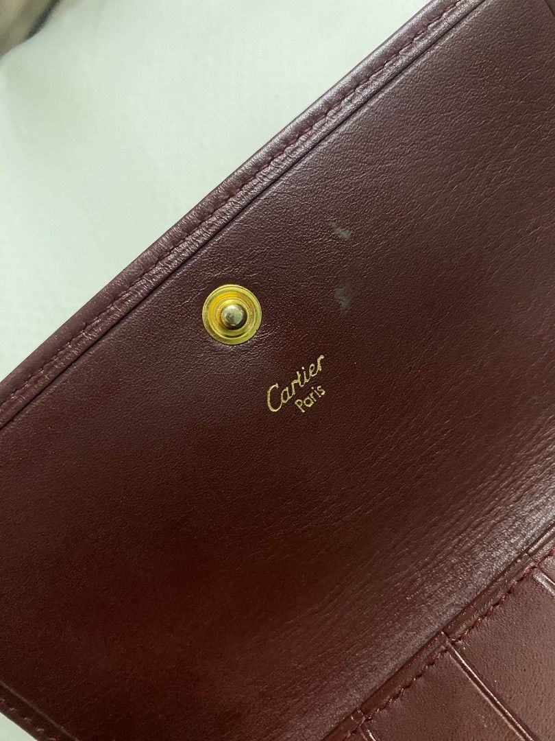 Cartier Bordeaux Leather Long Wallet (Category: Luxury Bags & Wallets) located in Naga. Submitted by mrwisethrifter (Listing ID 1470846799, Image 3). Description: - Brand: Cartier - Material: Premium bordeaux leather with gold-tone hardware - Design: Embossed Cartier double C logo on front flap - Interior: Multiple card slots, bill compartments, and a kiss-lock coin pocket - Authenticity: Cartier Paris gold stamping on the interior leather flap -