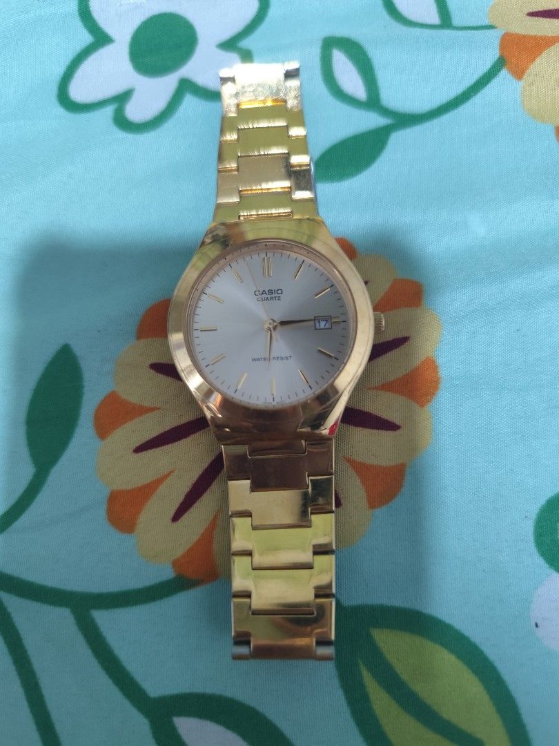 Casio Quartz Gold-Tone Watch with Date Display (Category: Women's Watches) located in Manila. Submitted by marriage031073advocate (Listing ID 1470756684, Image 1). Description: - Brand/Type: Gold-tone Casio quartz watch - Dial: White dial with gold hands and hour markers - Feature: Date window at the 3 o'clock position - Durability: Water-resistant construction - Closure: Link bracelet with fold-over clasp - Style: Classic everyday piece - Origin