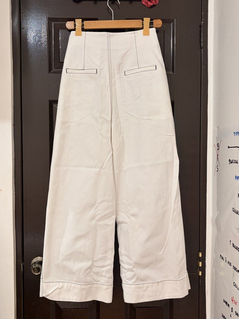 Cekeke White Wide Leg Pants Size M (Category: Jeans) located in Marikina City. Submitted by _bananahanaa (Listing ID 1470804297, Image 2). Description: - Brand: Cekeke - Size: M (160/64A measurements) fits 27 waist - Color: Clean white with stylish contrast black stitching - Fit: High-waisted, wide-leg style - Details: Pleated waist, front button placket, 2 functional side pockets, and faux back pockets - Material: Cotton-like denim.