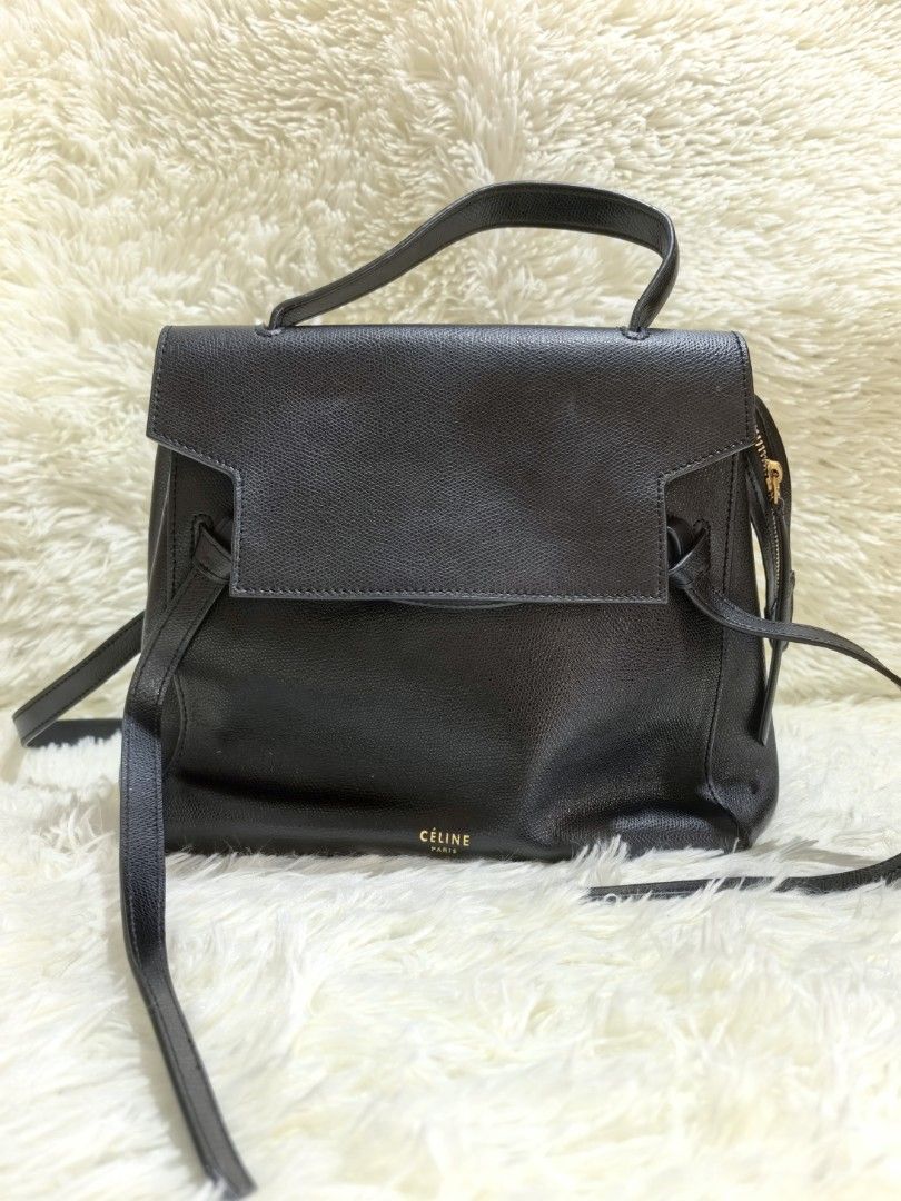 Celine Black Leather Handbag with Strap (Category: Luxury Bags & Wallets) located in Tacloban City. Submitted by thead.declutters (Listing ID 1470880079, Image 1). Description: - Material: Premium black textured leather with luxury gold-tone hardware - Versatility: Includes a sturdy top handle and a removable shoulder strap with clasp closure - Closure & Security: Flap top with a secure magnetic snap button - Pockets: Convenient exterior back zip
