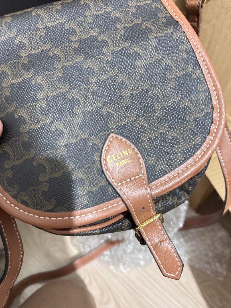 Celine Triomphe Canvas Saddle Crossbody Bag Brown (Category: Luxury Bags & Wallets) located in Manila. Submitted by dearpinkcollections (Listing ID 1470849506, Image 2). Description: - Authentic Celine crossbody bag in classic Triomphe monogram canvas - Tan leather trim with stylish white contrast stitching - Elegant gold-tone hardware and secure flap closure with buckle detail - Celine Paris logo stamped clearly on the front tab - Adjustable sho