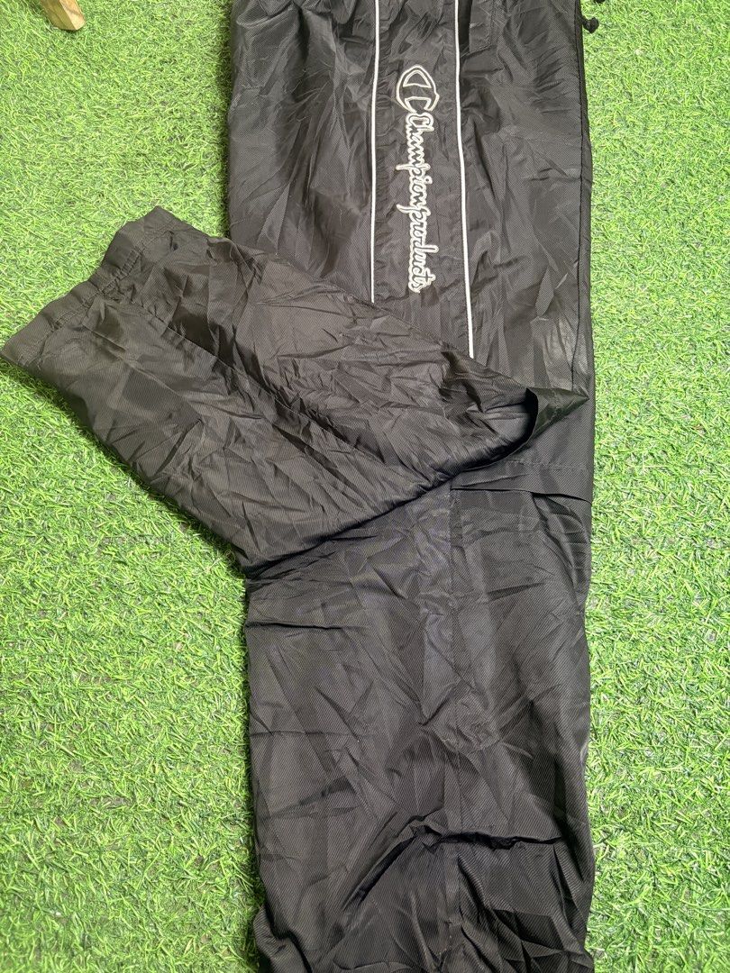 Champion track Pant (Category: Trousers) located in Manila. Submitted by josh2295 (Listing ID 1470761909, Image 2). Description: Champion black vintage nylon track pants (windbreaker trousers) with white side piping and vertical embroidered Champion script branding along the leg. W:30-26 L:40 LH:8.