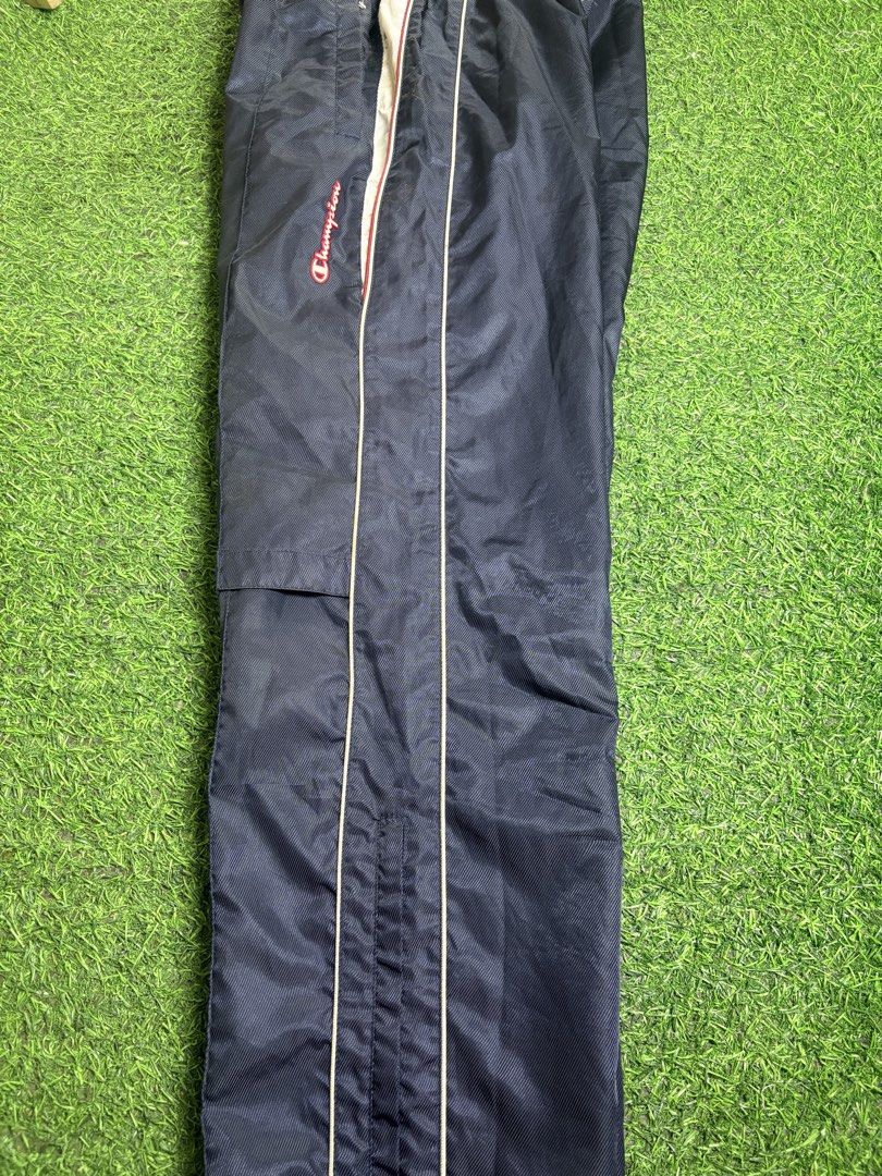 Champion Track Pant (Category: Trousers) located in Manila. Submitted by josh2295 (Listing ID 1470763547, Image 3). Description: vintage navy blue Champion nylon windbreaker track pants featuring a side logo script and red-and-white piping detail. W: 30- 34 L:40 LH: 9.