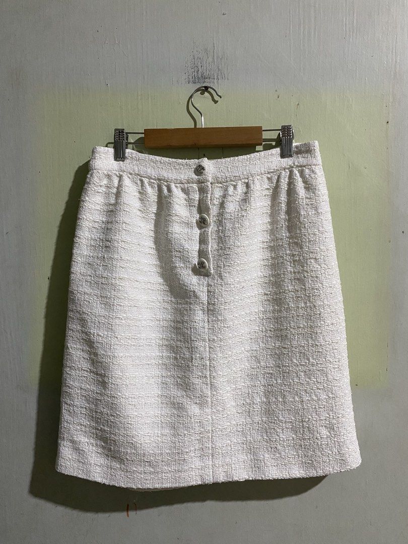 Chanel White Tweed Skirt Size 38 (Category: Skirts) located in Pandi. Submitted by nasya_thrift_collection2023 (Listing ID 1470858025, Image 1). Description: - French-made white tweed skirt - Size: 38 (EU) - Chic front button closure with iconic CC logo hardware - Premium white silk inner lining for extra comfort - Cotton blend outer fabric - Perfect for smart-casual or formal looks .