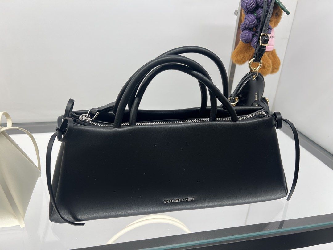 Charles & Keith Black Handbag CK2-20160193 (Category: Luxury Bags & Wallets) located in Lipa City. Submitted by thyra06 (Listing ID 1470852158, Image 2). Description: - Brand: Charles & Keith - Style: Structured Handbag with Top Handle (Style Code: CK2-20160193) - Size: Medium - Colour: Noir (Matte Black finish) - Features: Secure zip closure and elegant side ribbon detail - Condition: Brand new with original store price tag still attached to the