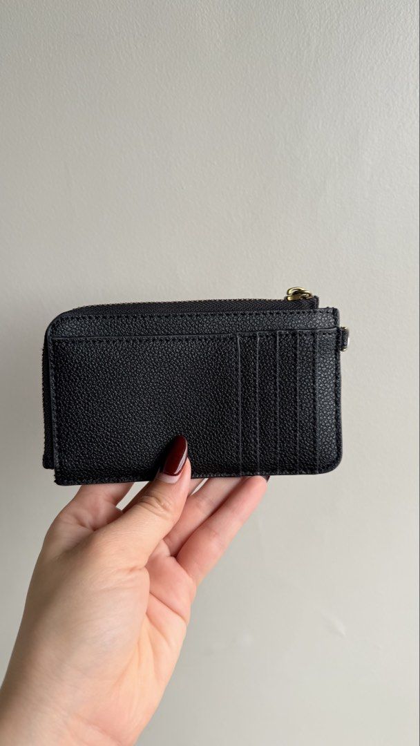 Charles & Keith Black Zip Cardholder with Wristlet Strap (Category: Wallets & Card holders) located in Pasay City. Submitted by maviemavz (Listing ID 1470794741, Image 2). Description: Material: Black pebble-textured faux leather - Secure zippered top compartment for coins/cash, multiple card slots on the back - Removable wristlet strap with gold-tone hardware, original dust bag, and box included - Clean inside and out and still in good condition