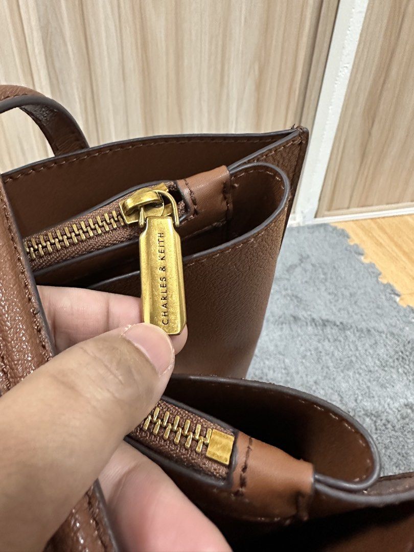 Charles & Keith Brown Tote Bag (Category: Tote Bags) located in Antipolo. Submitted by jloom (Listing ID 1470903994, Image 2). Description: - Brand: Charles & Keith - Color: Brown - Material: Textured leather finish - Hardware: Gold-toned - Bought P5000 at C&K shop in SM megamall lastyr 2025 - Used Trice, with dust bag (I have the paper bag kaso lukot na) - Can send other pic/video for checking -No issue. Papasa sa maarte. -RFS: Need to declutter