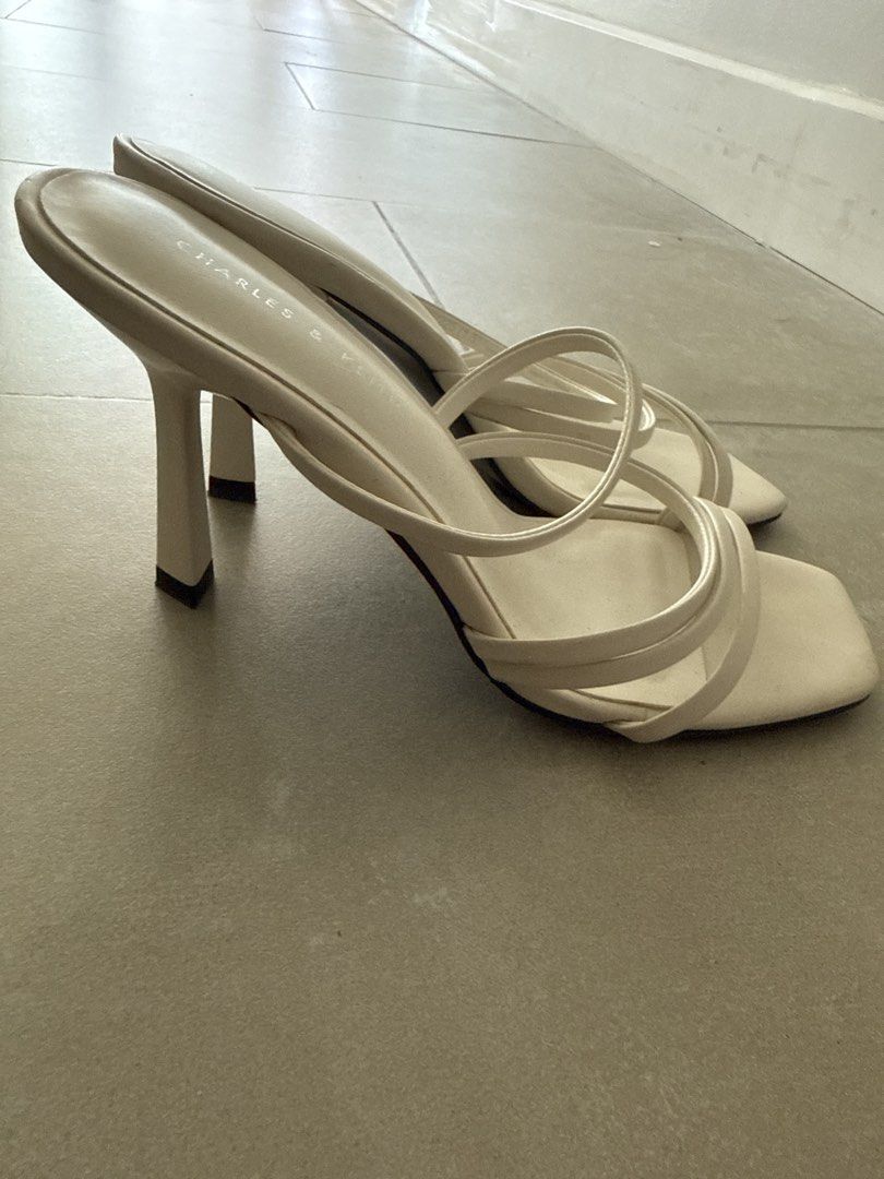 Charles & Keith White Strappy Heeled Mules (Category: Heels) located in Makati City. Submitted by cagal.i0n (Listing ID 1470757388, Image 3). Description: - Brand: Charles & Keith - Color: Clean minimalist white - Style: Slip-on mules with chic square toe - Heel: Slim stiletto heels 3” - Design: Multiple thin straps across the top of the foot - Condition: Excellent / Well-maintained - Mode of Payment: GCash, BPI, - Shipping: Via J&T Express or La