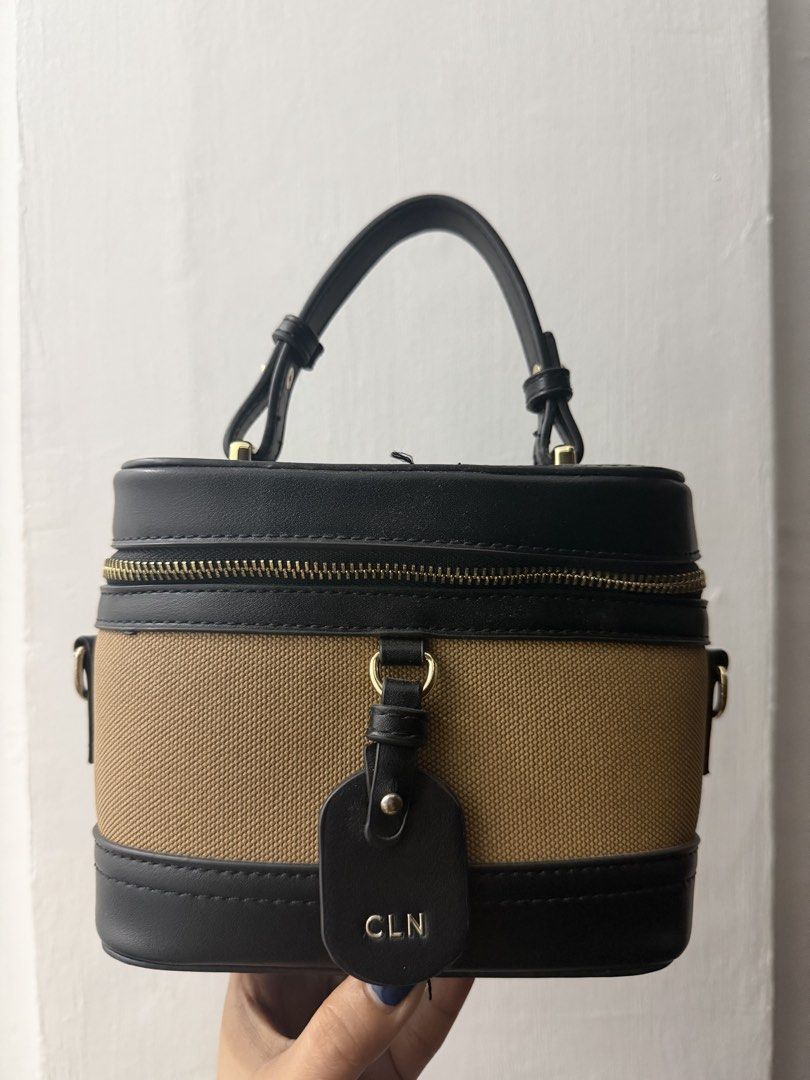 CLN Black and Tan Vanity Bag (Category: Luxury Bags & Wallets) located in Quezon City. Submitted by skyleeeee (Listing ID 1470919174, Image 1). Description: - Brand: CLN - Color: Black and tan - Style: Structured vanity handbag with top handle - Closure: Zip-around - Hardware: Gold-tone - Interior: Printed fabric lining - Extras: Includes matching black detachable shoulder strap and front CLN logo tag MOP: gcash bank transfer Delivery: Same day v