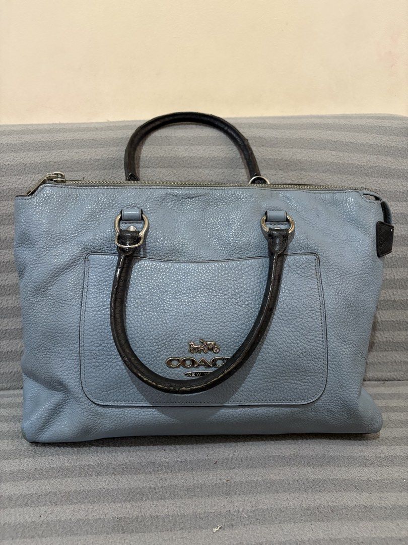 Coach Blue Leather Tote Bag With Front Pocket (Category: Luxury Bags & Wallets) located in Pasig City. Submitted by mau_llamas (Listing ID 1470876727, Image 1). Description: - Coach leather tote bag in dusty blue with pebbled texture - Features dark contrast handles and sleek silver hardware - Metallic Coach logo stamp on the front pocket - Secure zip-top closure - Spacious dark fabric-lined interior with organizational pockets and official Coach