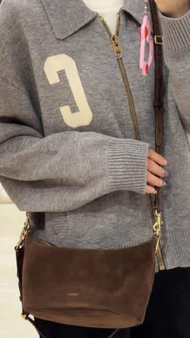 Coach Brown Suede Shoulder Bag (Category: Luxury Bags & Wallets) located in Benito Soliven. Submitted by angelgumta83832 (Listing ID 1470800409, Image 2). Description: - Authentic Coach shoulder bag in rich dark brown suede - Elegant gold-tone hardware and secure top zip closure - Adjustable leather strap equipped with stylish dog leash clasps - Subtle Coach New York gold logo stamped near the base - Soft texture with clean lines, perfect for eve