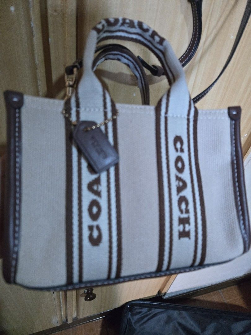 Coach Canvas Mini Tote Bag Brown Cream (Category: Luxury Bags & Wallets) located in Quezon City. Submitted by mycloset_2016 (Listing ID 1470768071, Image 2). Description: - Brand: Coach - Style: Mini tote bag - Material: Cream canvas with brown leather trim - Design: Bold Coach logo printed on front - Straps: Dual top handles and adjustable brown crossbody strap - Hardware: Gold-tone with matching hanging tag - Closure: Snap closure with clean in