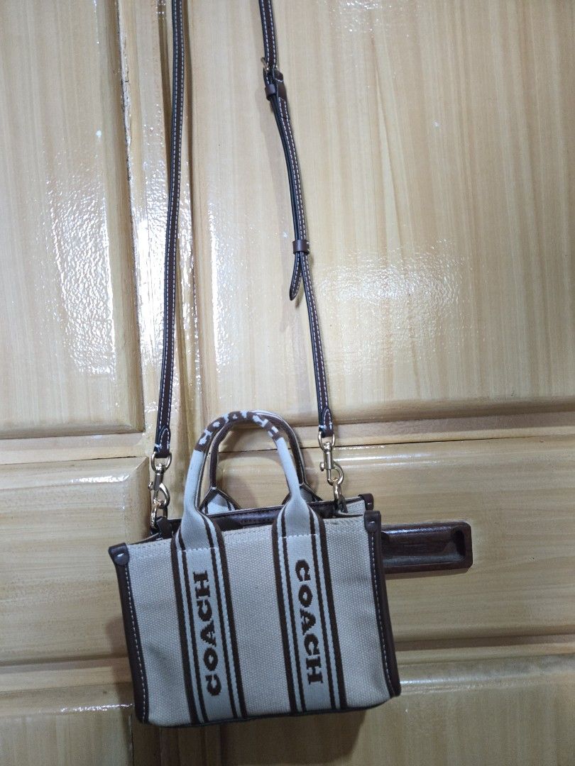 Coach Canvas Mini Tote Bag Brown Cream (Category: Luxury Bags & Wallets) located in Quezon City. Submitted by mycloset_2016 (Listing ID 1470768071, Image 3). Description: - Brand: Coach - Style: Mini tote bag - Material: Cream canvas with brown leather trim - Design: Bold Coach logo printed on front - Straps: Dual top handles and adjustable brown crossbody strap - Hardware: Gold-tone with matching hanging tag - Closure: Snap closure with clean in