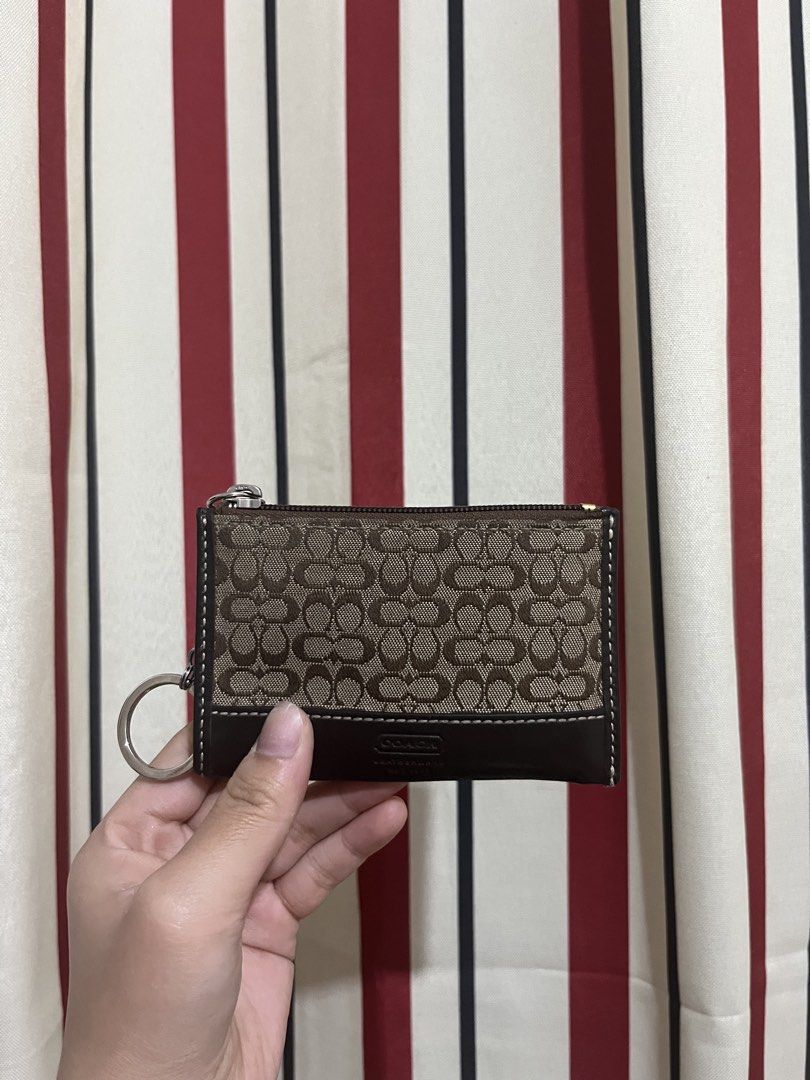 Coach Card Holder Wallet (Category: Wallets & Card holders) located in General Santos City (Dadiangas). Submitted by cinnamongirlypop (Listing ID 1470855875, Image 1). Description: - Authentic Coach signature C pattern on brown canvas fabric - Stylish dark brown leather trim with embossed logo patch - Secure top zipper closure with silver-tone pull - Convenient built-in keyring loop on the side - Compact size, perfect for cards, cash, and keys - 