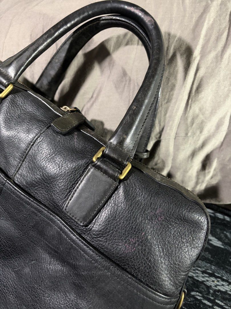 Coach Crosby Briefcase (no strap) (Category: Briefcases) located in Manila. Submitted by jjprelovedcollections2 (Listing ID 1470897027, Image 3). Description: - Brand: Coach - Material: Black leather with brass hardware - Compartments: Dual top carry handles, front zippered pocket, back slip pockets, and includes leather hang tag - Condition: Heavy wear on handles, bottom corners, base panel, with scuffs and fading across the leather surface .