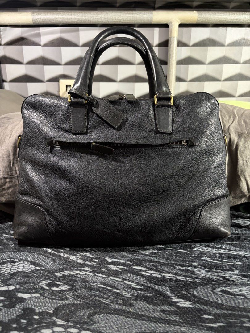 Coach Crosby Briefcase (no strap) (Category: Briefcases) located in Manila. Submitted by jjprelovedcollections2 (Listing ID 1470897027, Image 1). Description: - Brand: Coach - Material: Black leather with brass hardware - Compartments: Dual top carry handles, front zippered pocket, back slip pockets, and includes leather hang tag - Condition: Heavy wear on handles, bottom corners, base panel, with scuffs and fading across the leather surface .