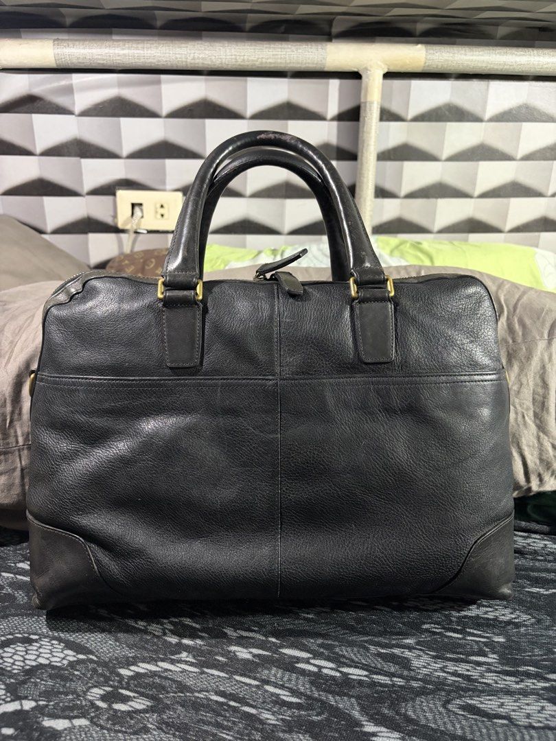 Coach Crosby Briefcase (no strap) (Category: Briefcases) located in Manila. Submitted by jjprelovedcollections2 (Listing ID 1470897027, Image 2). Description: - Brand: Coach - Material: Black leather with brass hardware - Compartments: Dual top carry handles, front zippered pocket, back slip pockets, and includes leather hang tag - Condition: Heavy wear on handles, bottom corners, base panel, with scuffs and fading across the leather surface .