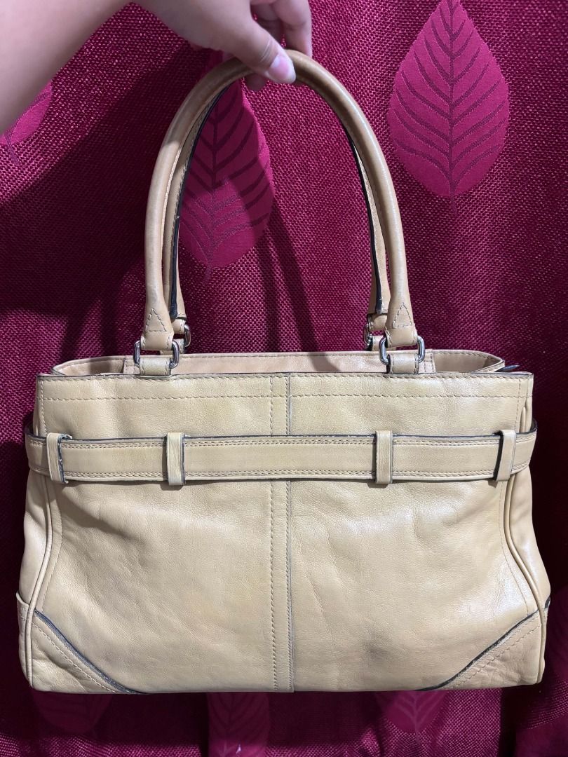 Coach Hampton Leather Tote Bag Tan (Category: Luxury Bags & Wallets) located in Taguig. Submitted by classicurations (Listing ID 1470835142, Image 2). Description: Tan leather tote bag. Dual top handles and silver tone hardware. Front clasp closure with matching belt detail. Includes Coach hangtag. Interior creed patch reads style number A0851-F11200, crafted in China from natural cowhide leather. Fabric lined interior with zip pocket. Shows mino