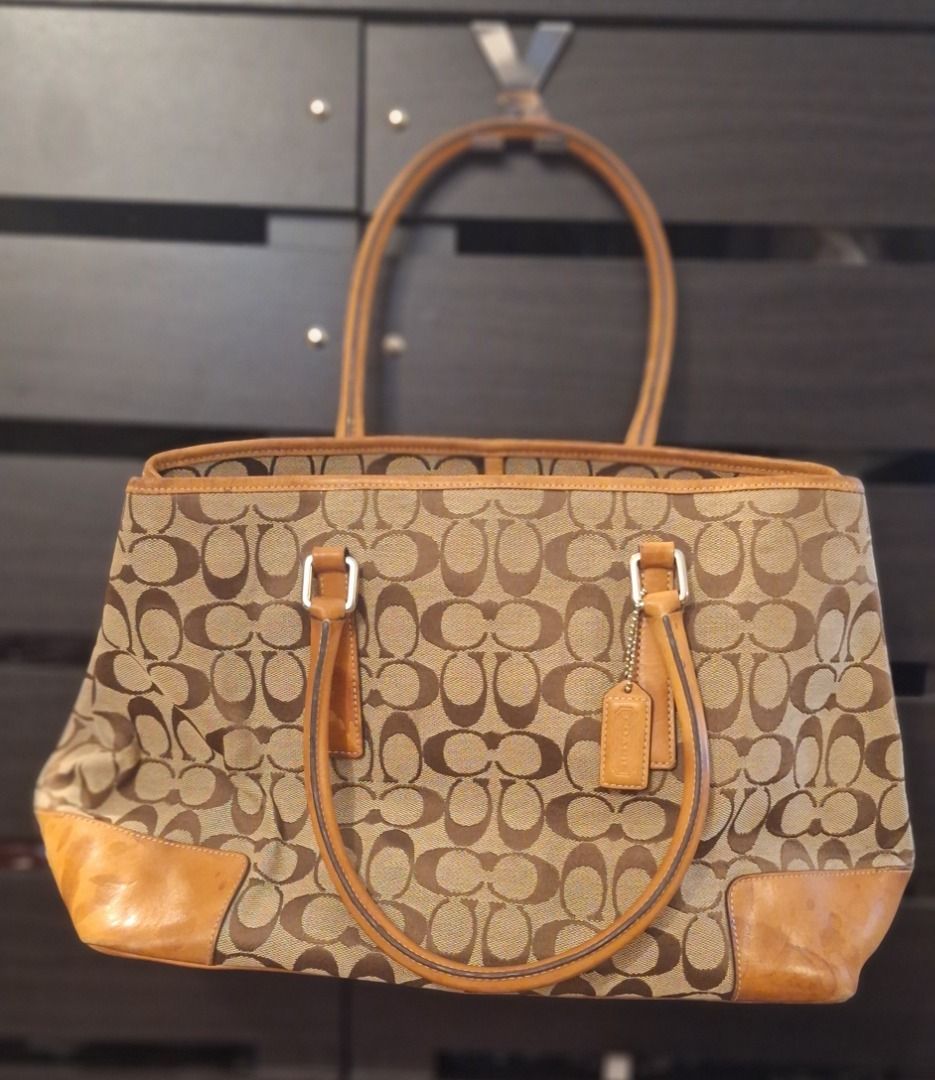 COACH Large Bag (Category: Luxury Bags & Wallets) located in General Trias. Submitted by aeunice (Listing ID 1470807118, Image 1). Description: Brand: Coach In Good Condition. Authentic Coach Signature C canvas tote in classic brown and tan, accented with elegant leather trim and sturdy dual handles. Features a vibrant orange interior with convenient pockets for organizing your essentials, along with protective metal feet on the base to help keep