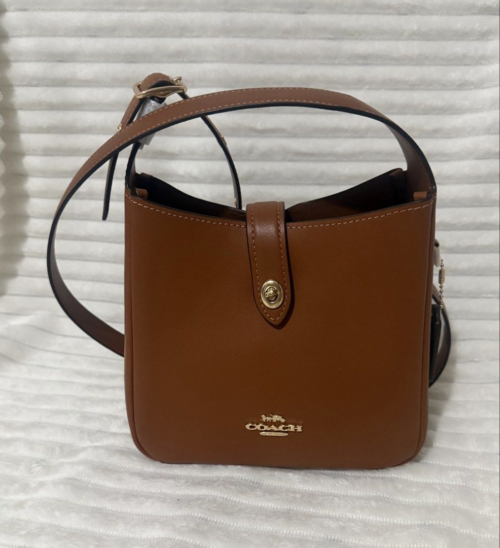 Coach Mini Hadley Bag (Category: Luxury Bags & Wallets) located in Las Pinas. Submitted by purse.vanity (Listing ID 1470832672, Image 2). Description: - Brand: Coach - Style: Leather bucket bag - Color: Rich saddle brown with gold-tone hardware - Condition: Brand new with tags still attached - Features: Structured shape, signature metal logo, and center turn-lock strap closure - Interior: Fabric lining with an inside zip pocket Adjustable strap c