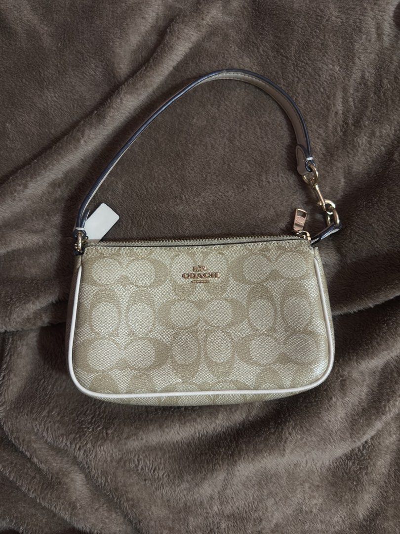 Coach Signature Canvas Mini Bag Beige White (Category: Luxury Bags & Wallets) located in Manila. Submitted by lexxi.00 (Listing ID 1470878447, Image 1). Description: - Authentic Coach mini shoulder bag in signature beige coated canvas - Chic white leather piping and polished gold-tone hardware - Secure zipper top closure with a fabric-lined interior and built-in card slots - Includes a versatile detachable strap and matching leather hangtag - Com