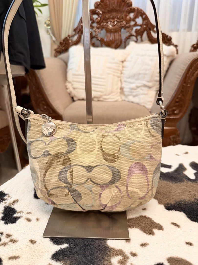Coach Signature Multi-Color Canvas Shoulder Bag (Category: Cross-body Bags) located in Santiago. Submitted by yrellagnoihsaf (Listing ID 1470772494, Image 3). Description: - Authentic Coach signature canvas shoulder bag - Multi-color pastel C pattern with elegant cream leather trim - Top zip closure and front zip pocket with pull tab - Silver-tone hardware and matching leather hangtag - Light purple satin interior lining with an additional zip po
