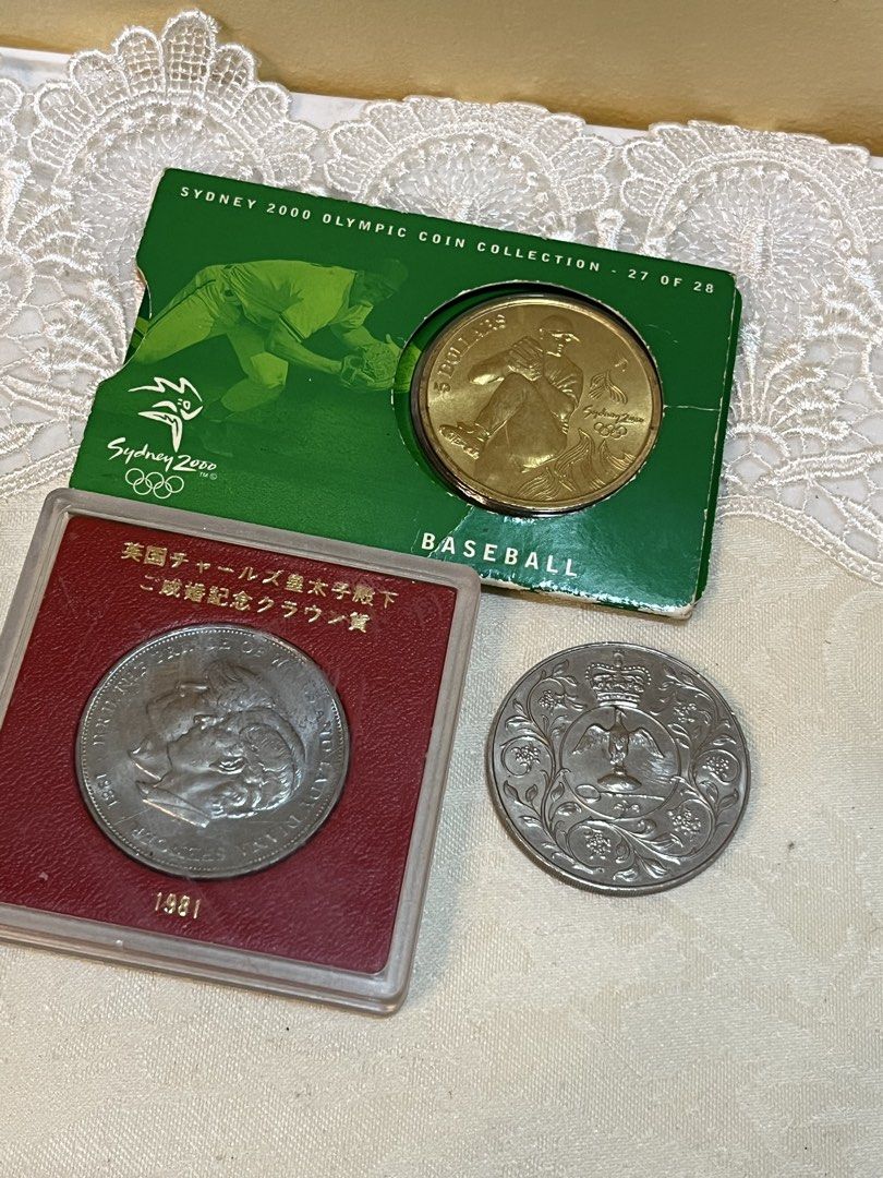 Collectible coin (Category: Currency) located in Dasmarinas. Submitted by emmakim08 (Listing ID 1470839582, Image 1). Description: Take all 500 only - 3-in-1 Collectible Coin Bundle - Sydney 2000 Olympic Coin (Baseball theme, Green packaging, Piece #27 of 28) - 1981 British Commemorative Crown Coin in a red display case - Extra silver-toned decorative coin featuring floral and crown engravings - Great addition to any coin collection or sports mem
