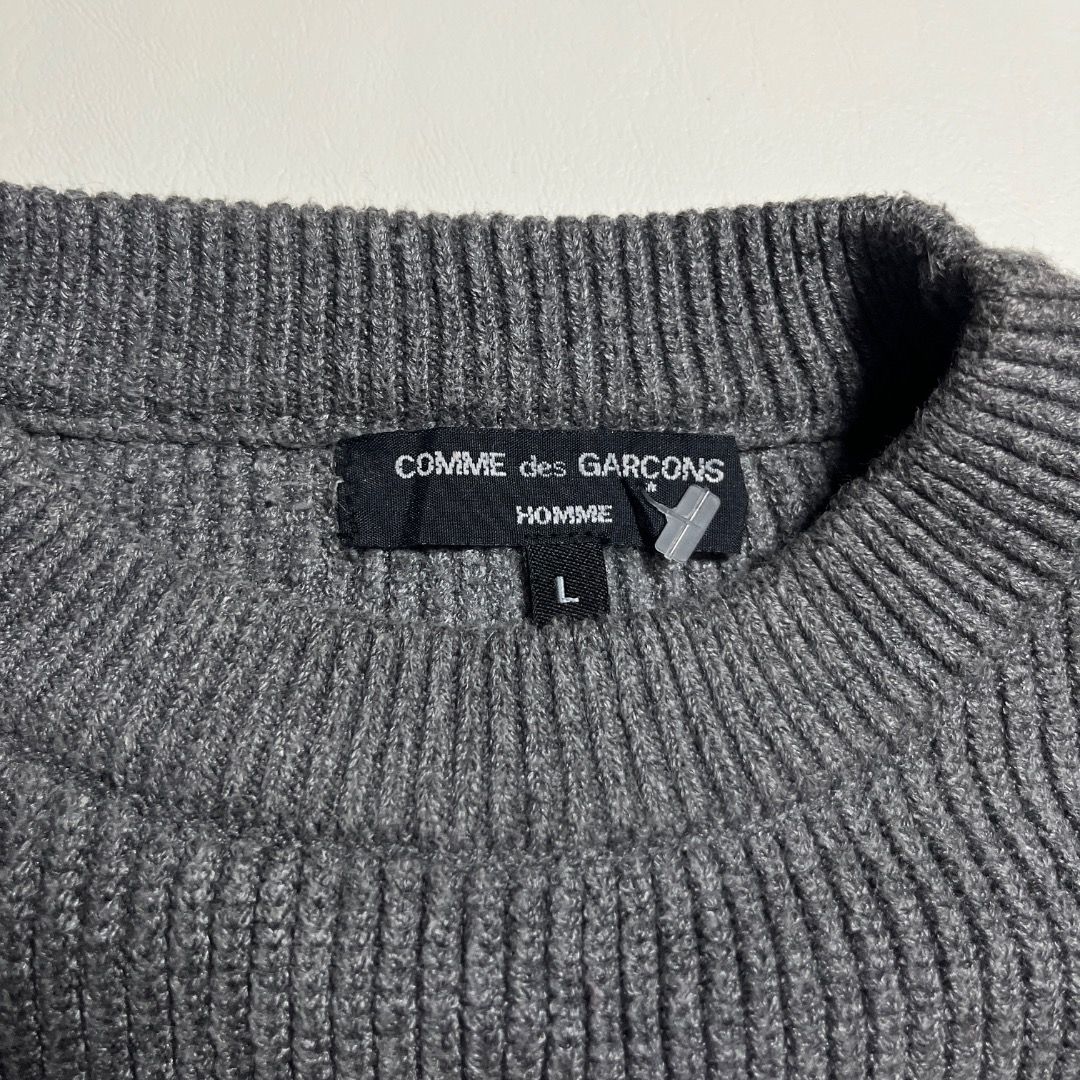 Comme des Garcoms Grey Knit Long Sleeve Sweater (Category: Longsleeves) located in Caloocan City. Submitted by achilles_grails (Listing ID 1470834671, Image 3). Description: - Color: Grey - Style: Classic crew neckline with textured waffle knit pattern - Fit: Relaxed fit through arms and torso for maximum comfort - Details: Ribbed cuffs and hem - Material: Warm knit fabric, ideal for cooler weather - Condition: Clean collar label intact.