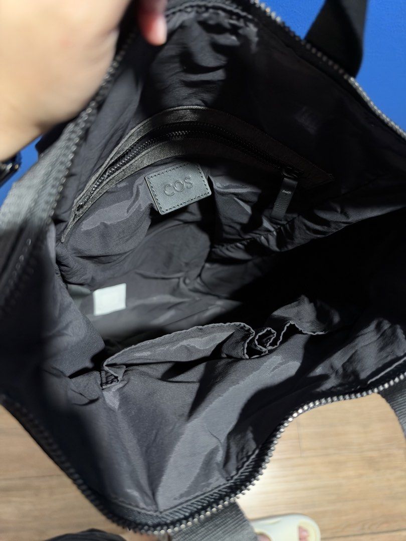 COS grey-and-black tote-backpack (Category: Backpacks) located in Manila. Submitted by garagesalebykoda (Listing ID 1470816388, Image 3). Description: - Brand: COS - Color: Dark Grey - Material: Sturdy canvas with durable webbing details - Convertible design: Easily switches between a tote bag and a backpack - Straps: Adjustable shoulder straps and dual top carry handles - Closure: Secure zip top closure - Interior features: COS branded leather p
