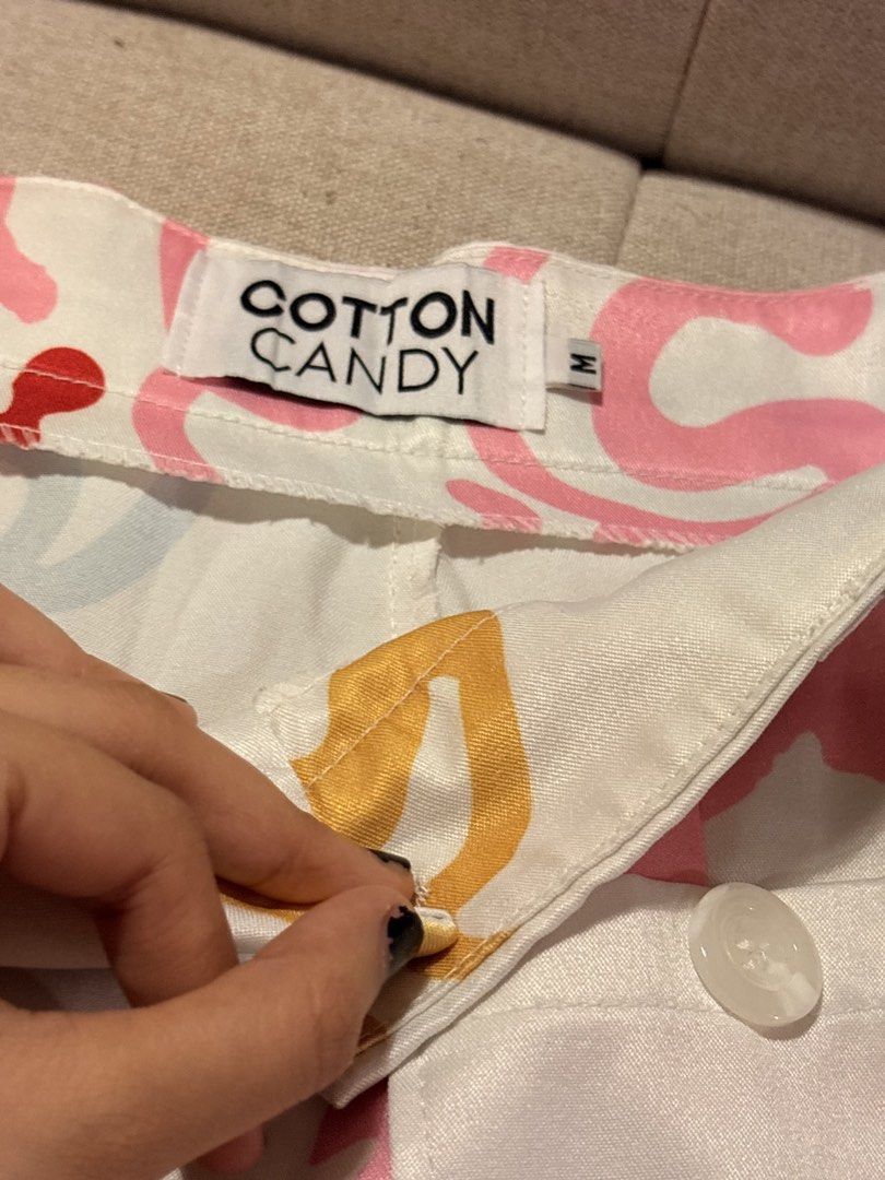 Cotton Candy Abstract Print Pants Size M (Category: Jeans) located in Pasig City. Submitted by shitaku.ph (Listing ID 1470856707, Image 3). Description: - Brand: Cotton Candy - Size: M (tag attached) - Color: White with multicolored abstract print (pink, green, yellow, blue swiggles and geometric shapes) - Features: Back pockets with white buttons, belt loops, zip fly with button closure - Condition: Brand new with tags.