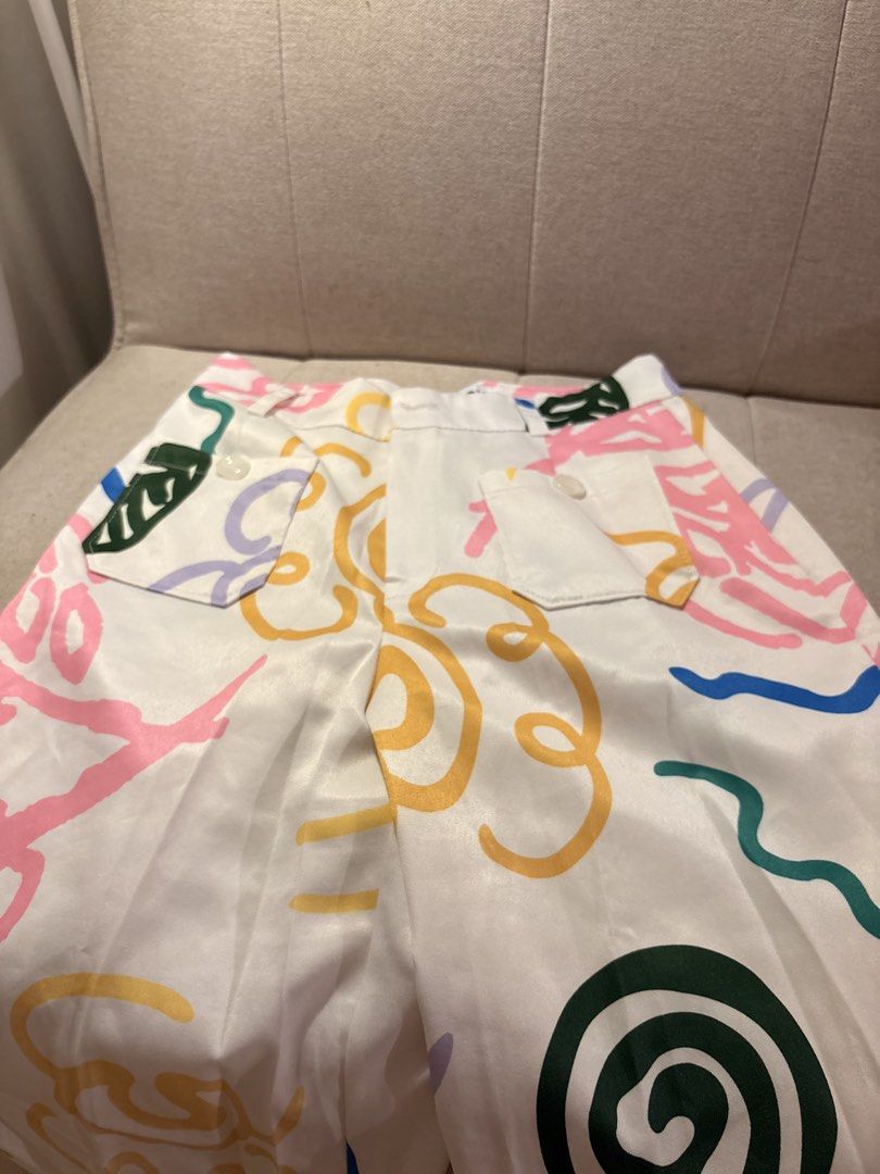 Cotton Candy Abstract Print Pants Size M (Category: Jeans) located in Pasig City. Submitted by shitaku.ph (Listing ID 1470856707, Image 2). Description: - Brand: Cotton Candy - Size: M (tag attached) - Color: White with multicolored abstract print (pink, green, yellow, blue swiggles and geometric shapes) - Features: Back pockets with white buttons, belt loops, zip fly with button closure - Condition: Brand new with tags.