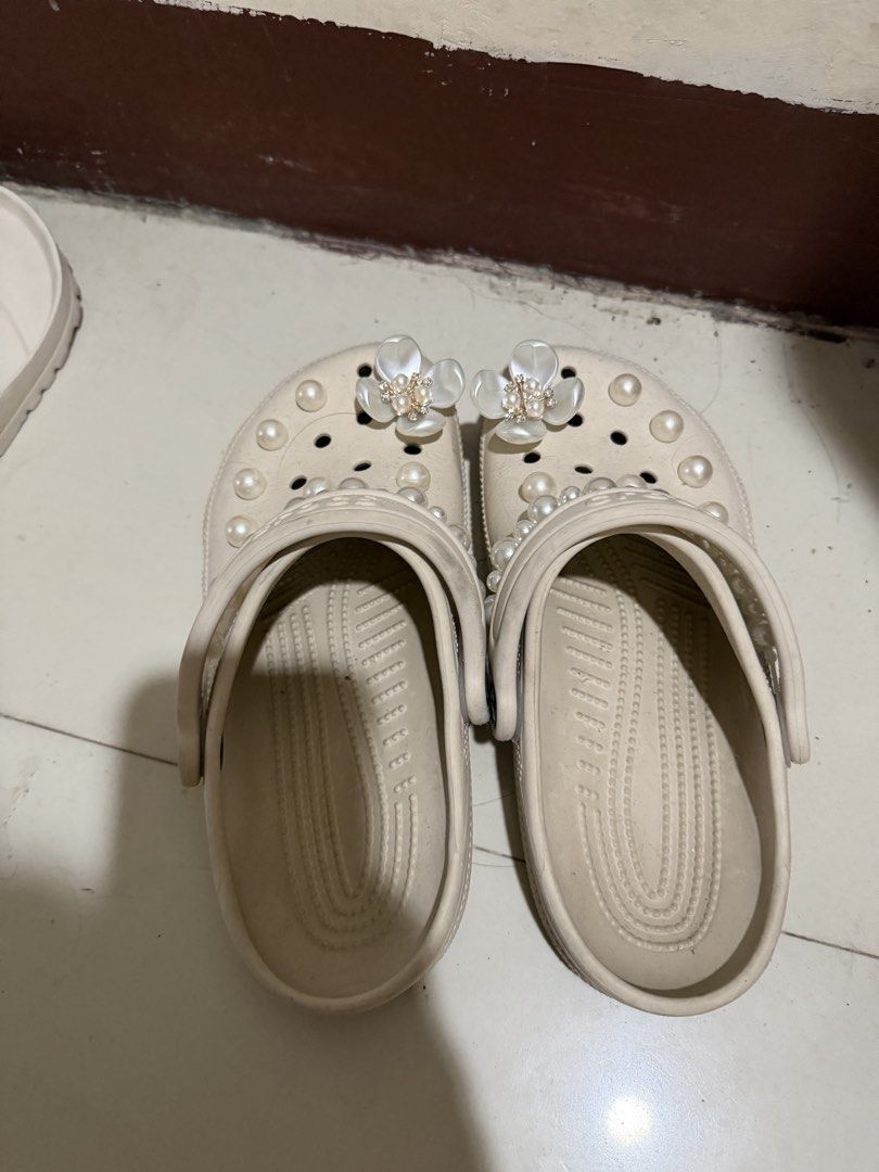 Crocs Custom Pearl and Flower Clogs Size M4 W6 (Category: Slippers and slides) located in Paranaque City. Submitted by mryjwll (Listing ID 1470929277, Image 3). Description: - Size: M4/W6 - Color: Stucco - Style: Slip-on with pivoting heel straps - Customization: Adorned with pearl chains and sparkling crystal flower charms - Condition: Soles show dirt and wear from previous use - Perfect for casual wear and everyday errands FREE GIRLY JIBBITZ WO