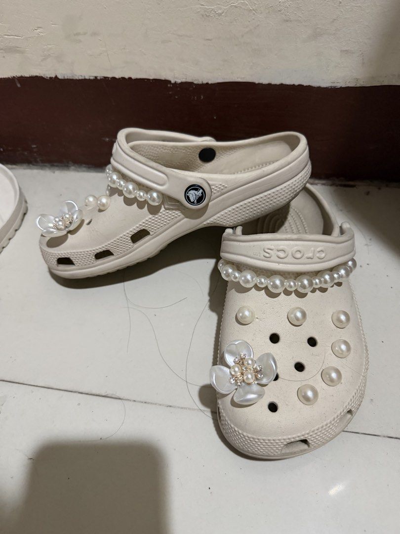 Crocs Custom Pearl and Flower Clogs Size M4 W6 (Category: Slippers and slides) located in Paranaque City. Submitted by mryjwll (Listing ID 1470929277, Image 2). Description: - Size: M4/W6 - Color: Stucco - Style: Slip-on with pivoting heel straps - Customization: Adorned with pearl chains and sparkling crystal flower charms - Condition: Soles show dirt and wear from previous use - Perfect for casual wear and everyday errands FREE GIRLY JIBBITZ WO