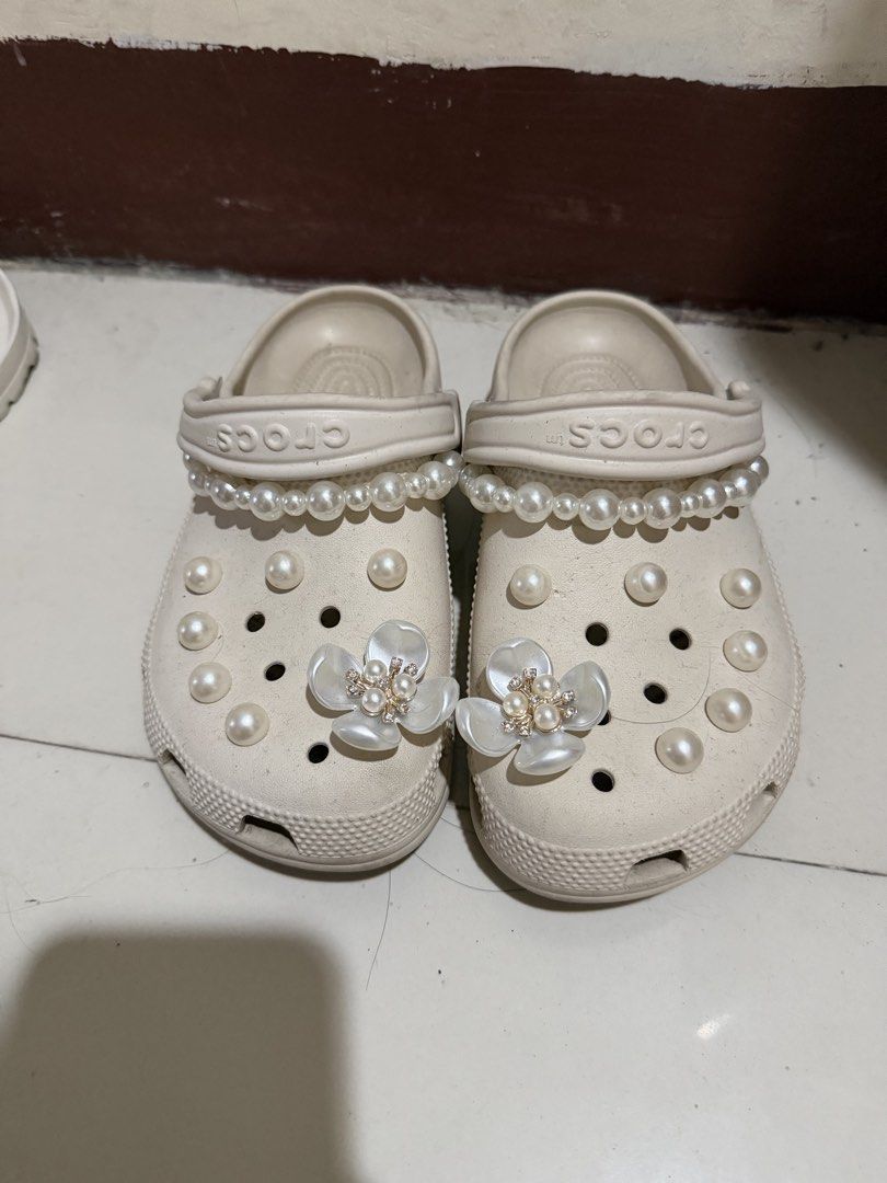 Crocs Custom Pearl and Flower Clogs Size M4 W6 (Category: Slippers and slides) located in Paranaque City. Submitted by mryjwll (Listing ID 1470929277, Image 1). Description: - Size: M4/W6 - Color: Stucco - Style: Slip-on with pivoting heel straps - Customization: Adorned with pearl chains and sparkling crystal flower charms - Condition: Soles show dirt and wear from previous use - Perfect for casual wear and everyday errands FREE GIRLY JIBBITZ WO